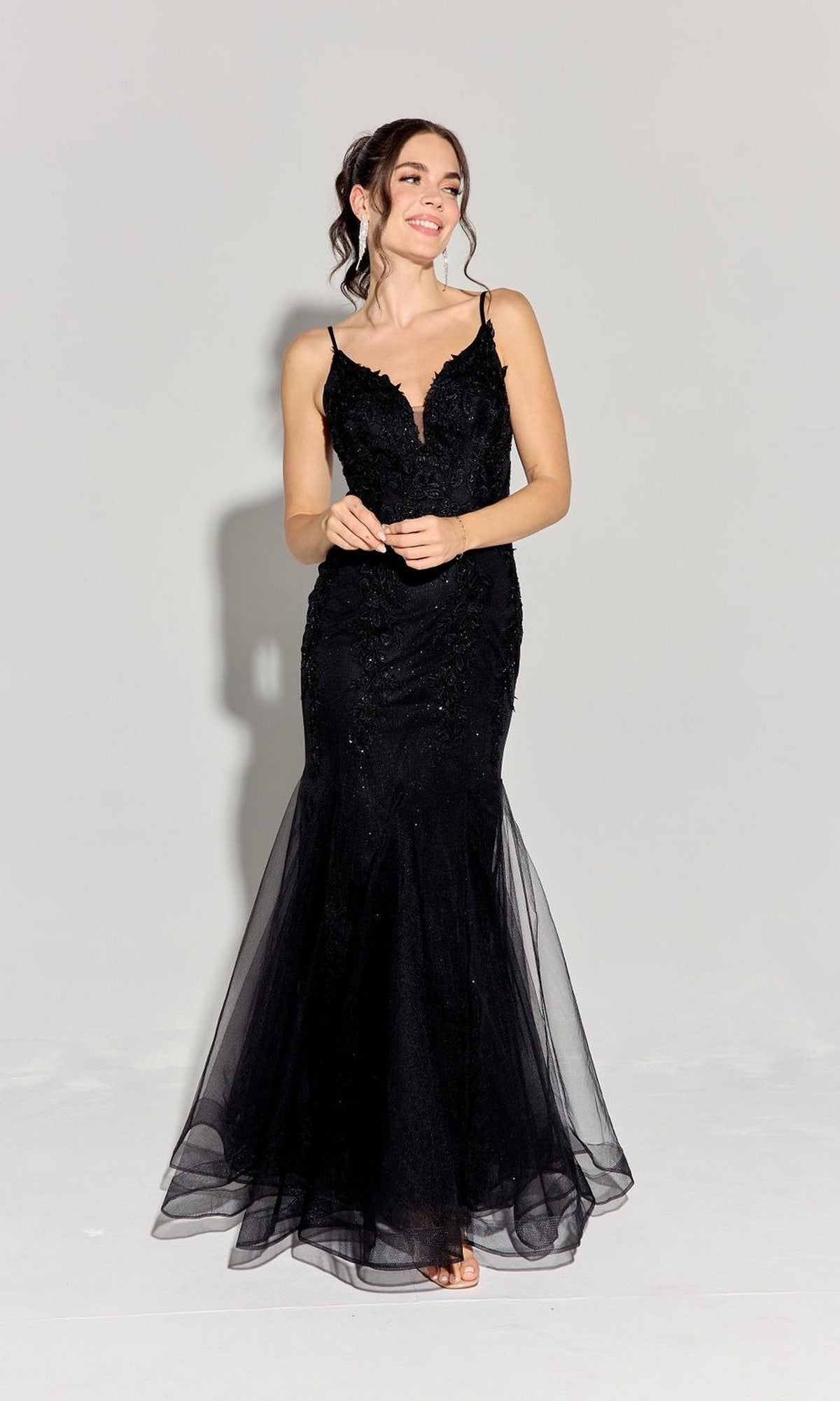 A woman models the Eureka 9998 long prom dress in black, featuring a sleeveless, fitted bodice and mermaid godet silhouette, standing against a plain light background.